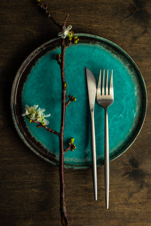 Spring table setting with cutlery and blooming cherry branch on rustic background with copy spaceの写真素材