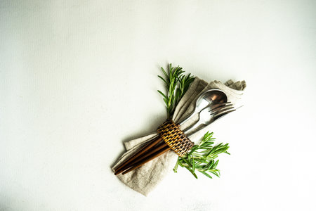Minimalistic cutlery setting with rosemary herb on concrete background with copy spaceの写真素材