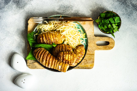 Vegetarian dinner concept with baked potatoe, spinach and cabbage salad on concrete background with copy spaceの写真素材