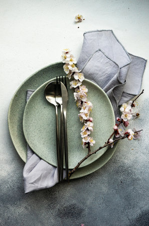 Minimalistic cutlery sett wih apricot blossom on concrete background with copy spaceの写真素材