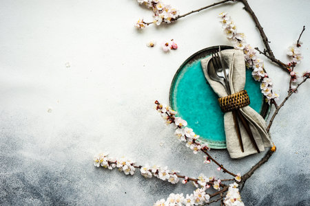 Minimalistic cutlery sett wih apricot blossom on concrete background with copy spaceの写真素材