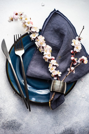 Minimalistic cutlery sett wih apricot blossom on concrete background with copy spaceの写真素材