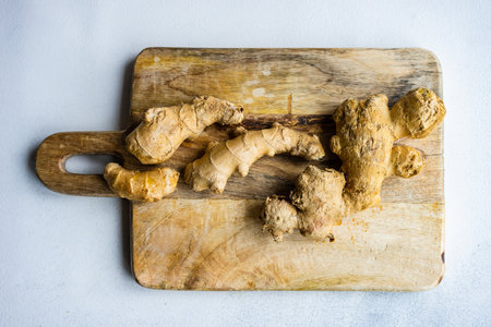 Ingredients for energy drink helping stay healthy with ginger roots on wooden boardの写真素材
