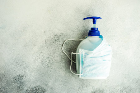 COVID-19 virus concept with face mask and soap on pastel background with copy spaceの写真素材