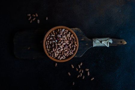Organic food concept with bowl full of beans on dark concrete background with copy spaceの写真素材