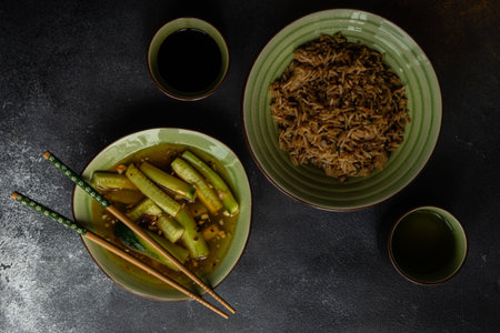 Traditional chinese food with fried rice with meat and cucumber in hot spicy sauce on concrete...