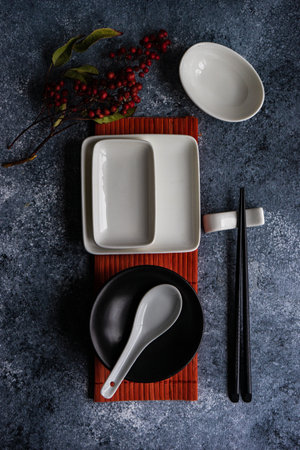 Asian table setting with wooden chopsticks and ceramic bowls on stone background with copy spaceの写真素材