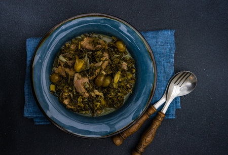 Chakapuli is a Georgian stew with tarragon and meat served in ceramic bowl on stone backgroundの写真素材