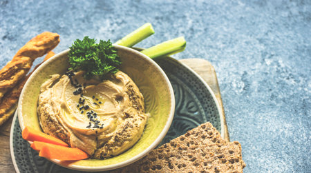Traditional chickpeas hummus with olive oil and sesame seeds on stone background with copy spaceの写真素材