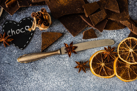 Chocolate bars, cinnamon and anise star spices on stone background with copy spaceの写真素材