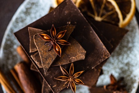 Chocolate bars, cinnamon and anise star spices on stone background with copy spaceの写真素材