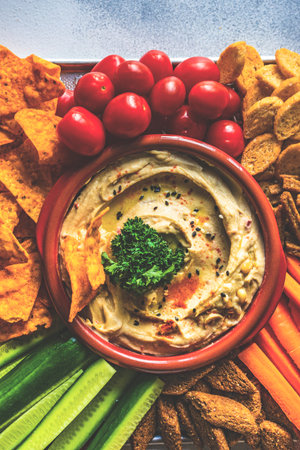 Traditional chickpeas hummus with olive oil and sesame seeds on stone background with copy spaceの写真素材