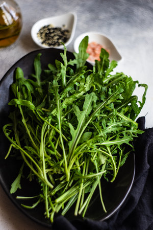 Healthy food concept with fresh organic arugula herb leaves on stone background with copy spaceの写真素材