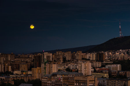 Moon rising over Tbilisi's downtown, capital of Georgiaの写真素材