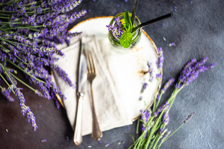 Summer time table set with minimalistic stoneware and cutlery served on concrete background and decorated with fresh lavender flowersの写真素材
