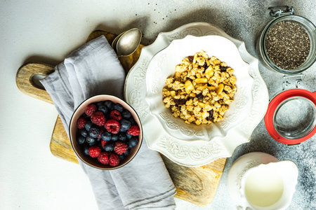 Breakfast food concept with cereals, yogurt and berries on concrete background with copy spaceの写真素材