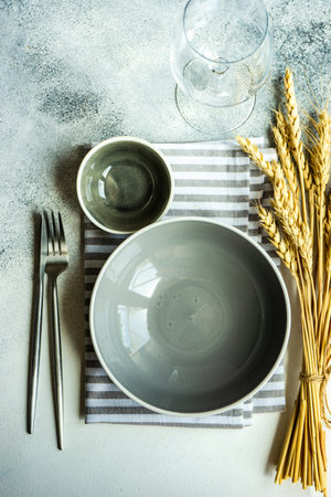 Rustic table setting with cutlery decorated with whear ears on concrete background with copy spaceの写真素材