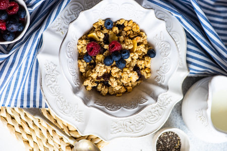 Breakfast food concept with cereals, yogurt and berries on concrete background with copy space