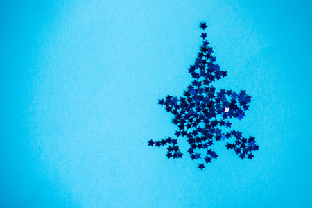 Festive Christmas card concept with star shaped decor on blue background with copy spaceの写真素材