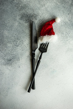 Cutlery set decorated with red hat on concrete background with copy spaceの写真素材