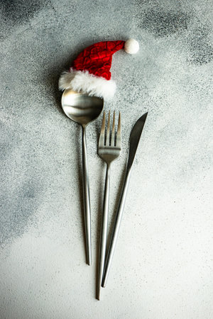 Cutlery set decorated with red hat on concrete background with copy spaceの写真素材