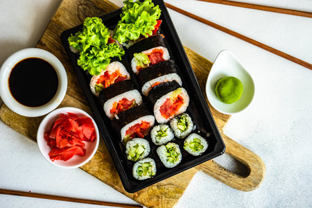 Sushi set  with futo maki and kappa maki served on stone table with chopsticksの写真素材