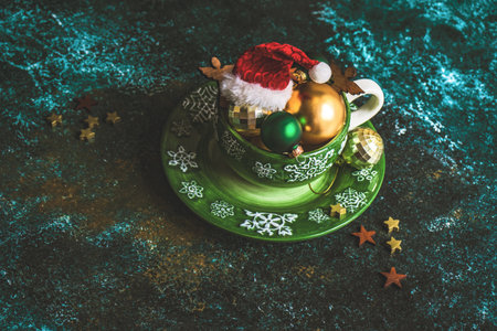 Chirstmas mug full of holiday decoration on green stone background with copy spaceの写真素材