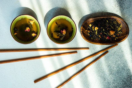 Asian style tea time drink concept with tea cups and chopsticks on white concrete background with copy spaceの写真素材