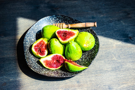 Organic figs with honey in a bowl on wooden table with copy spaceの写真素材