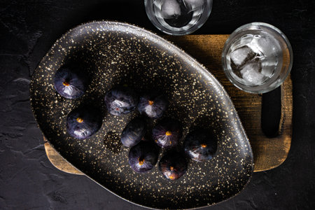 Organic figs with honey in a bowl on wooden table with copy spaceの写真素材