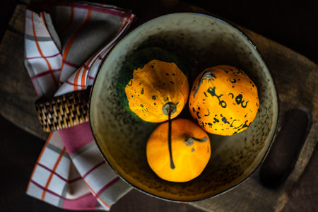 Plate on the table decorated with raw bright yellow pumpkin for Thanksgiving or Halloween dinner
