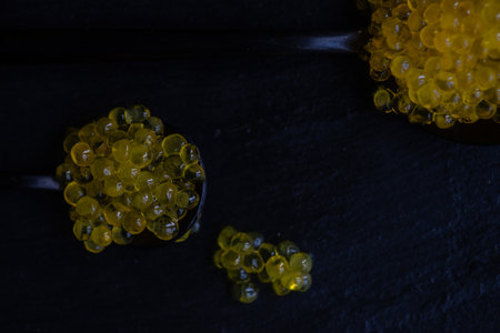 Yellow trour caviar on black background with copy spaceの写真素材