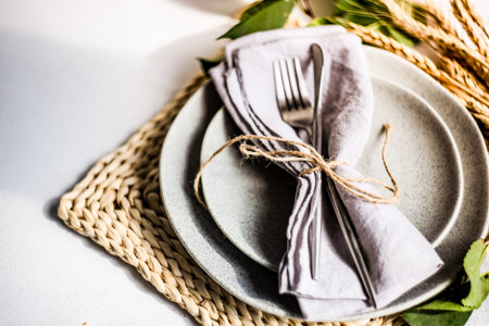 Empty plate and modern cutlry decorated with wheat ears on white stone background with copy spaceの写真素材