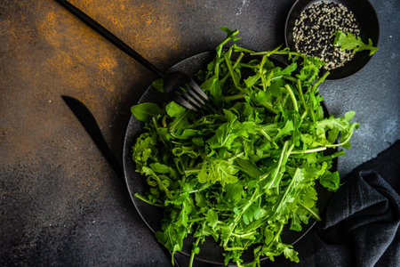 Organic food concept with fresh raw rucola leaves and pear slices with sesame seeds and olive oil on concrete background with copy spaceの写真素材
