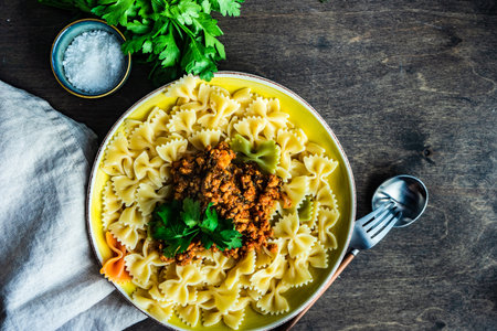 Pasta with carbonara sauce served in a bowl with fresh parsley herb on wooden table with copy spaceの写真素材