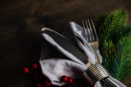 Christmas cutlery set with napkin and holiday decoration on wooden table