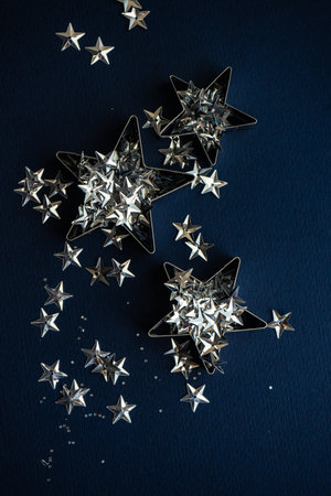 Sparkling star shaped decor on deep blue background as a Christmas card concept