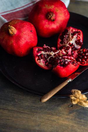 Organic pomegranate fruits with its seeds on plate as a organic food conceptの写真素材