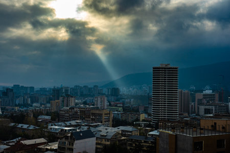 Wide angle view to the modern Tbilisi city centre in the autumnal morning with sunrays through the clousの写真素材