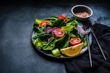 Healthy food salad with fresh organic spinach leaves with sesame seeds served in a bowl on concrete background with copy spaceの写真素材
