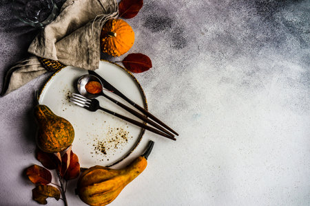 Autumnal place setting with yellow and red leaves on rustic background with copy spaceの写真素材