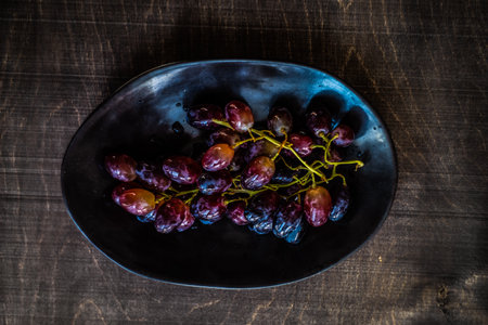 Fresh organic grape on the black plateの写真素材