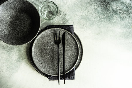 Minimalistic place setting with stone tableware on concrete backgroundの写真素材