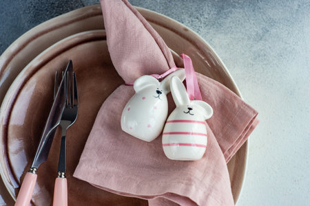 Minimalistic table setting for Easter dinner in pastel color on stone background with copy space