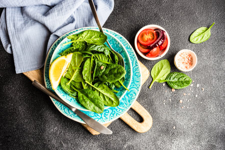 Healthy food salad with fresh organic spinach leaves with sesame seeds served in a bowl on concrete background with copy spaceの写真素材