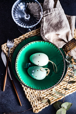 Festive place setting for Easter dinner with eggs on table