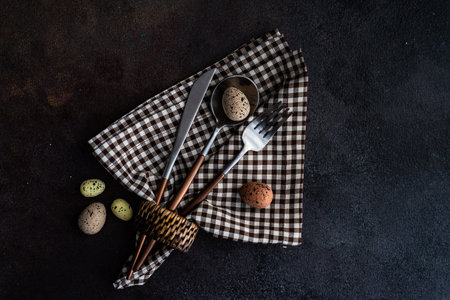Festive place setting for Easter dinner with eggs on tableの写真素材