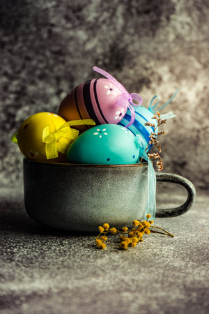 Place setting with ceramic bowl full of colored eggs for holiday easter dinnerの写真素材