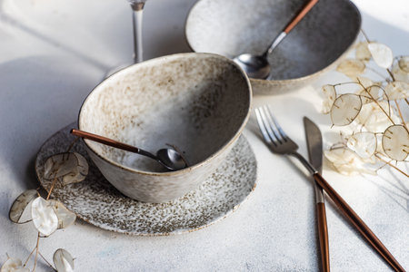 Minimalistic table setting in pastel colors on white concrete background