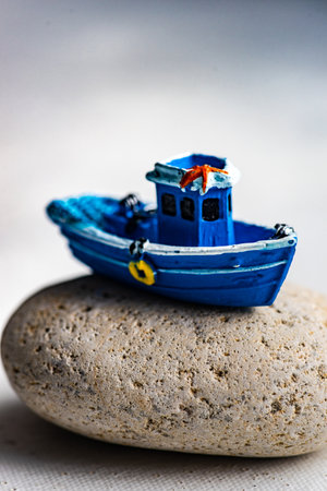 Summer card concept with blue sailor boat on sea stone on white backgroundの写真素材